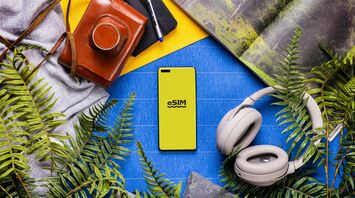 Smartphone with eSIM screen surrounded by travel accessories