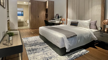 Modern hotel room with bed, desk and en-suite bathroom