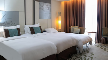 Modern hotel room with two beds and warm lighting