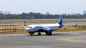 IndiGo aircraft taxiing at an airport in daylight