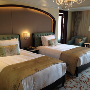 Twin-bed hotel room with elegant decor and armchairs