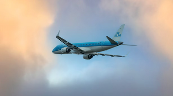 KLM aircraft flying through a colorful sky