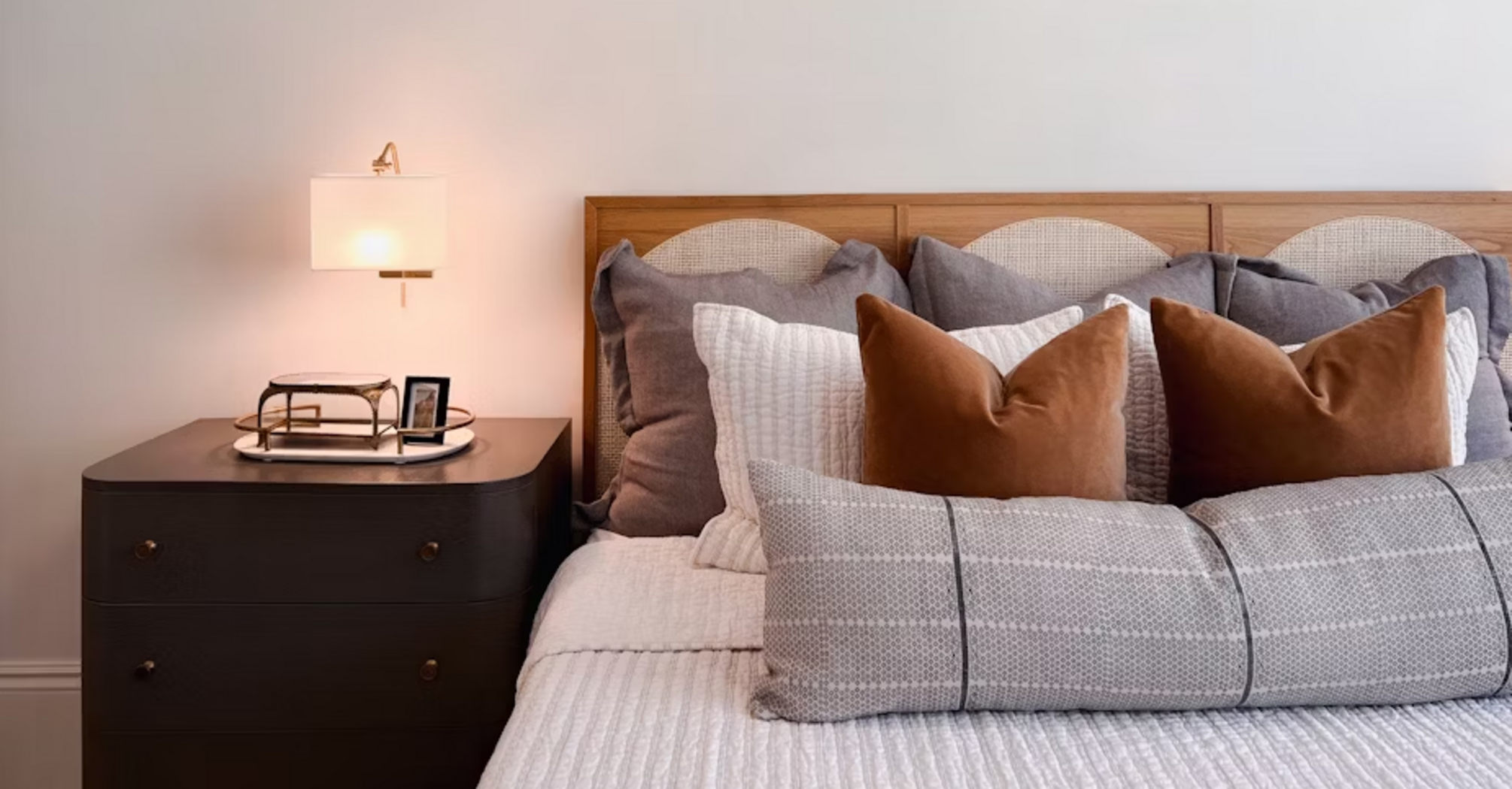 Cozy bedroom interior with modern bedside lamp and decorative pillows