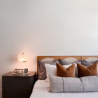 Cozy bedroom interior with modern bedside lamp and decorative pillows