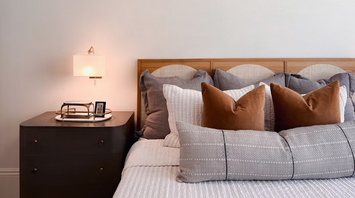 Cozy bedroom interior with modern bedside lamp and decorative pillows