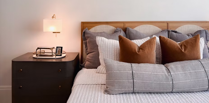 Cozy bedroom interior with modern bedside lamp and decorative pillows
