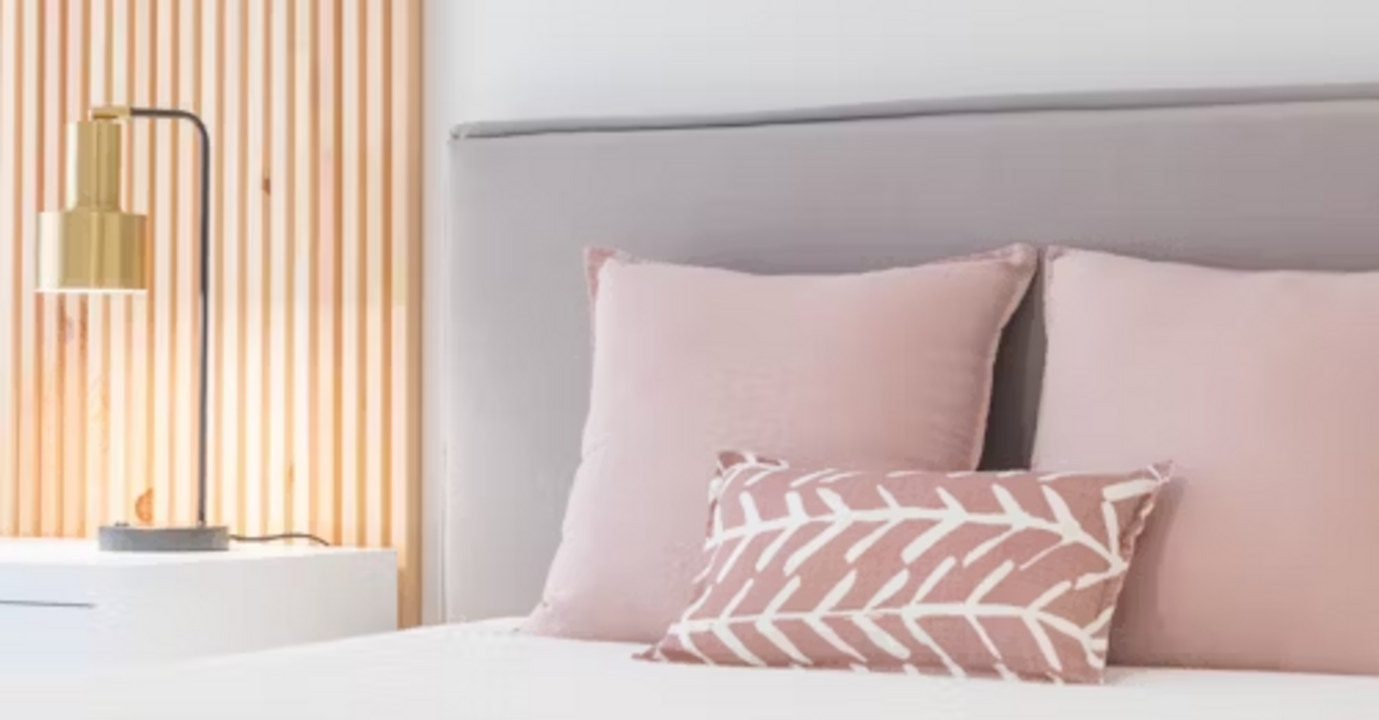 Modern bedroom with blush pink decor and minimalist lighting
