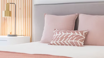 Modern bedroom with blush pink decor and minimalist lighting