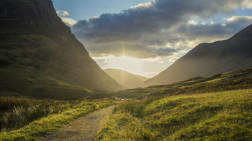 Hiking trail through Glencoe valley in the Scottish Highlands at sunset