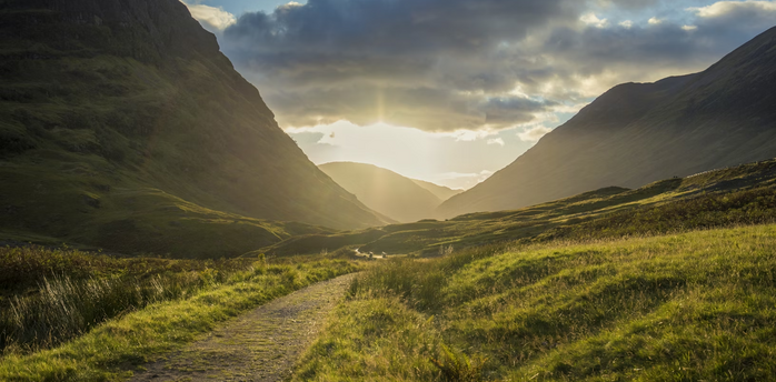 Hiking trail through Glencoe valley in the Scottish Highlands at sunset