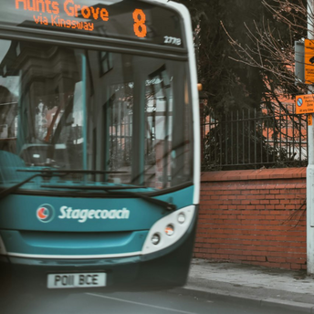 Stagecoach bus on urban street near brick wall and signposts