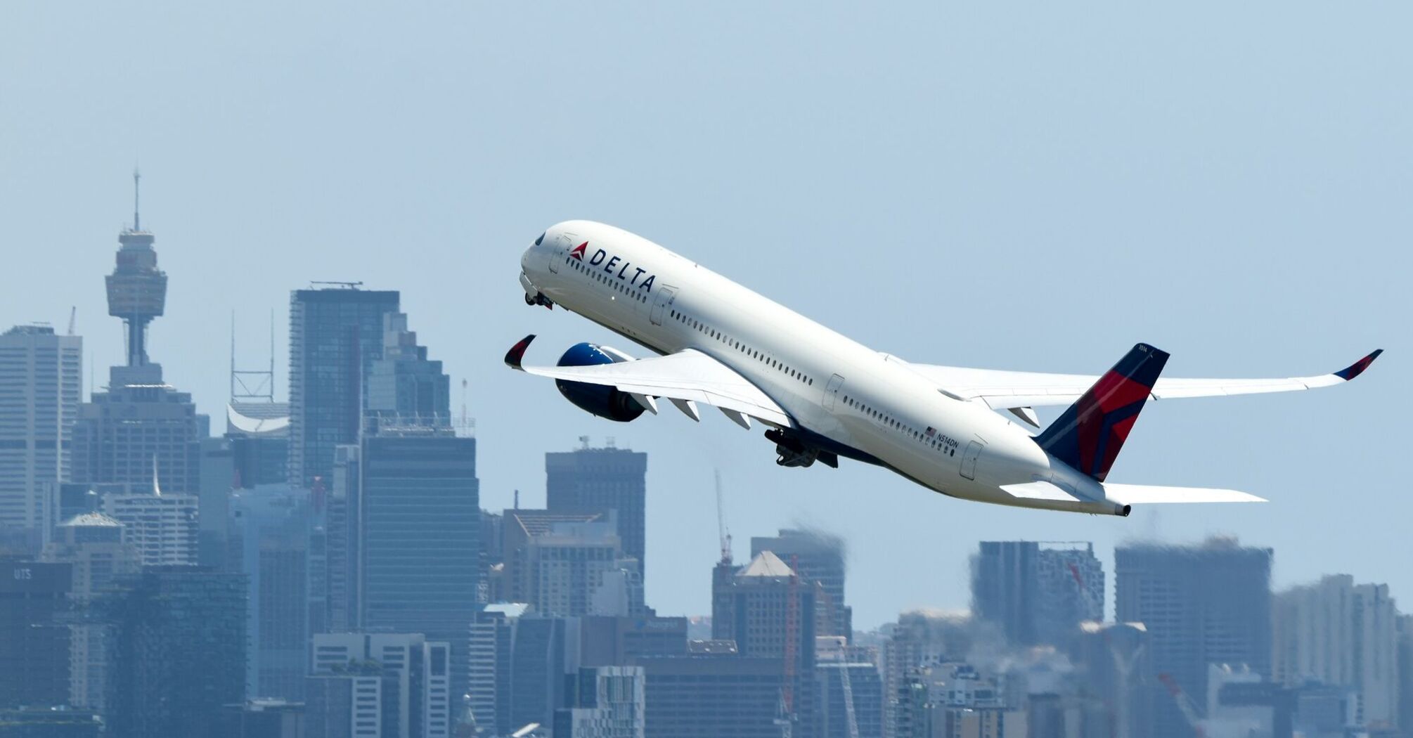 Delta Airbus A350 taking off over city skyline