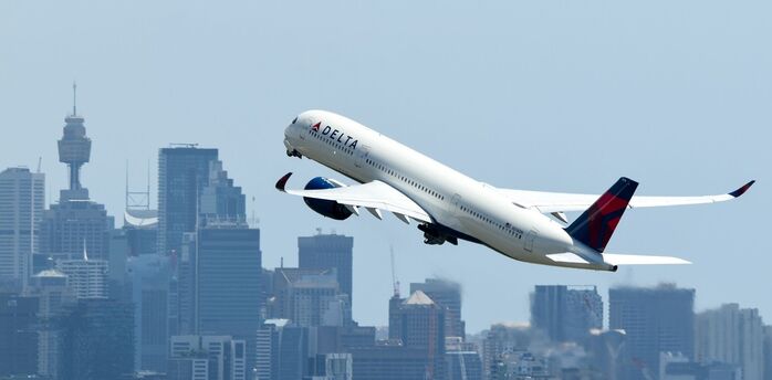 Delta Airbus A350 taking off over city skyline