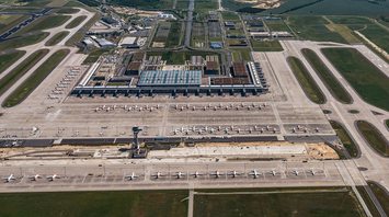 Aerial view of Berlin Brandenburg Airport showing multiple parked Ryanair planes and terminals