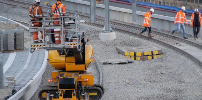 Railway workers performing track maintenance during station upgrade
