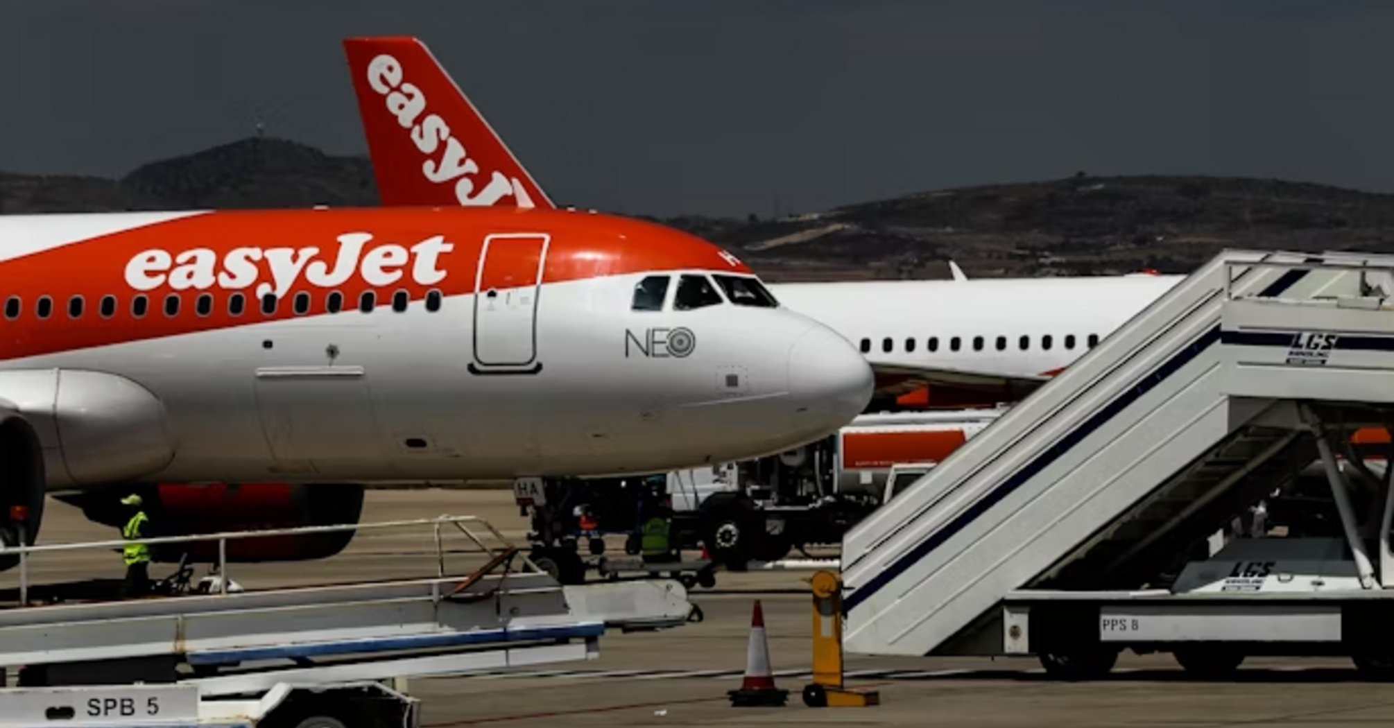 easyJet aircraft on airport tarmac with boarding stairs