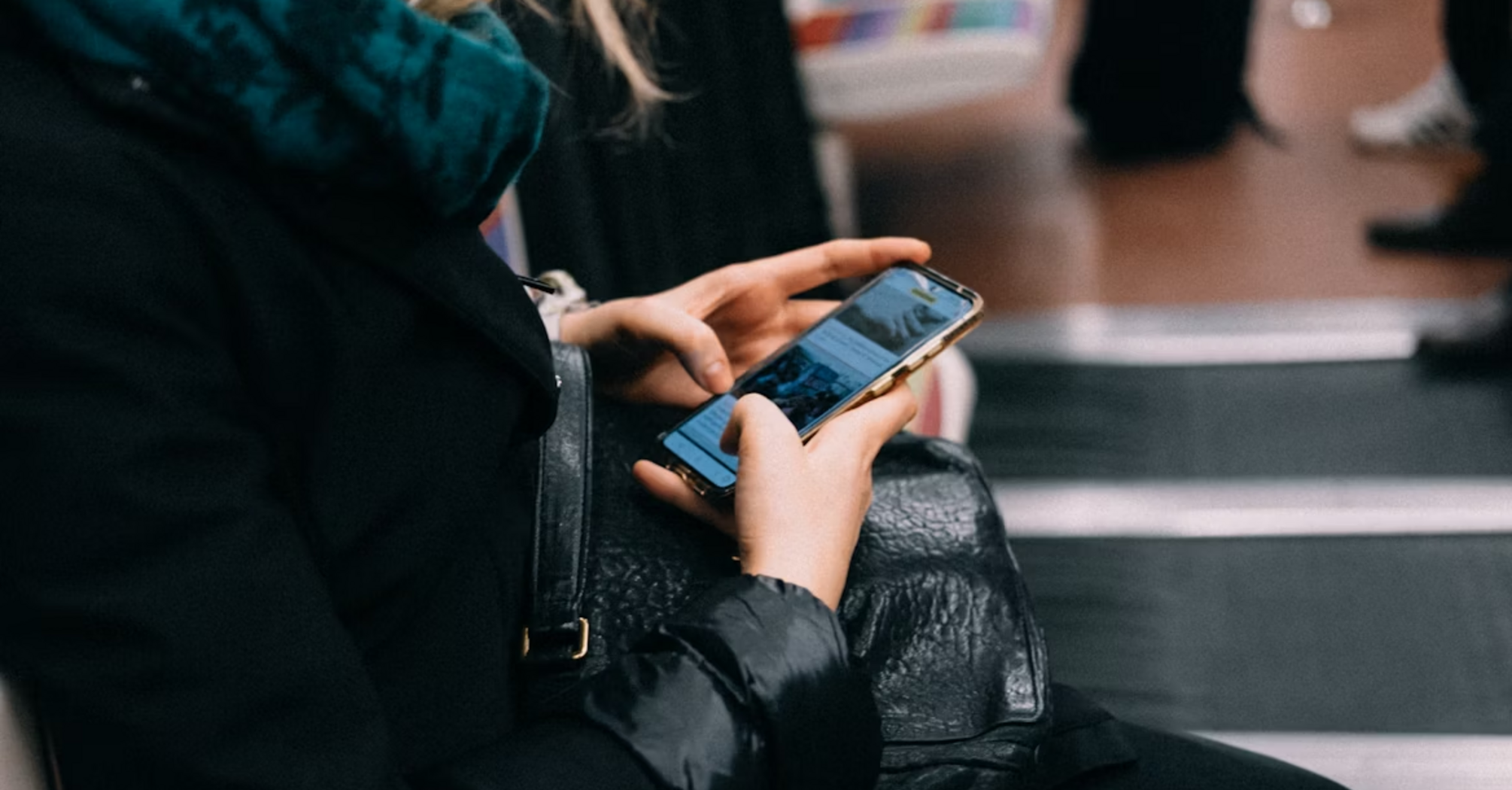A woman using her smartphone while sitting on public transport