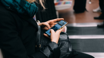 A woman using her smartphone while sitting on public transport