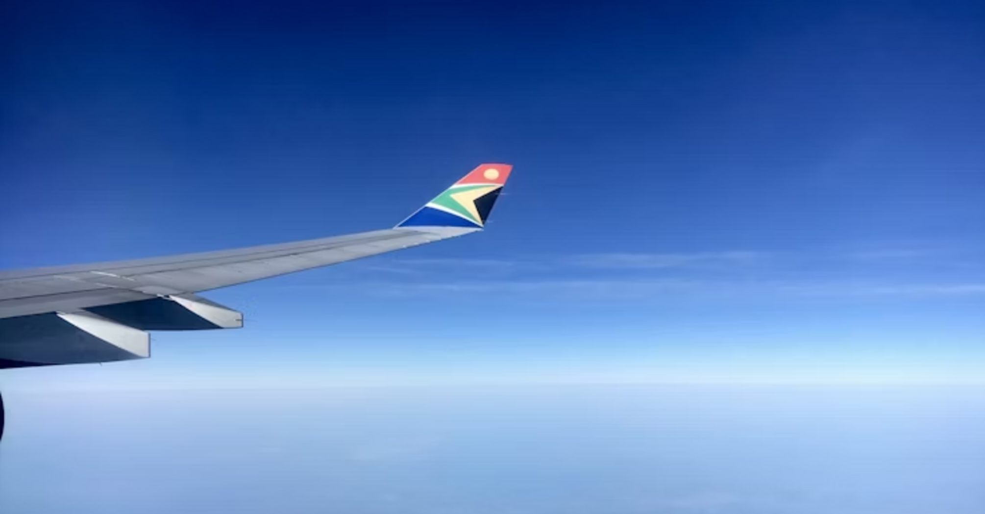 View of South African Airways wing over landscape during flight