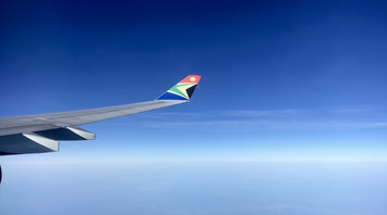 View of South African Airways wing over landscape during flight