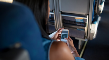 Woman checking travel information on her phone during a flight