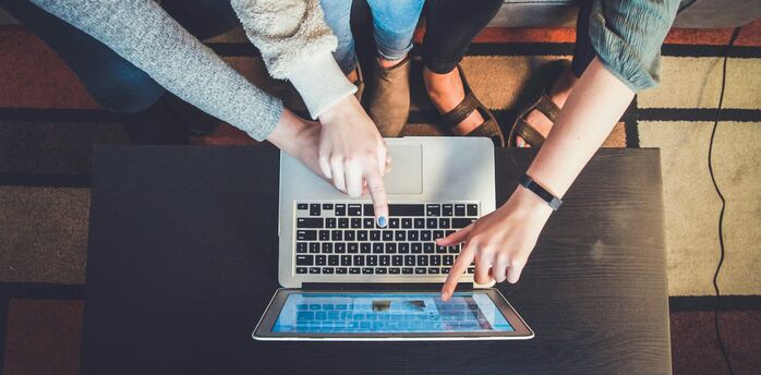 People using a laptop together to book travel online