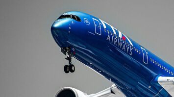 Blue ITA Airways aircraft taking off against grey sky