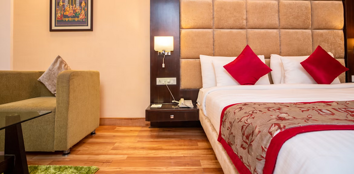 Modern hotel room with double bed, armchair, and wall art