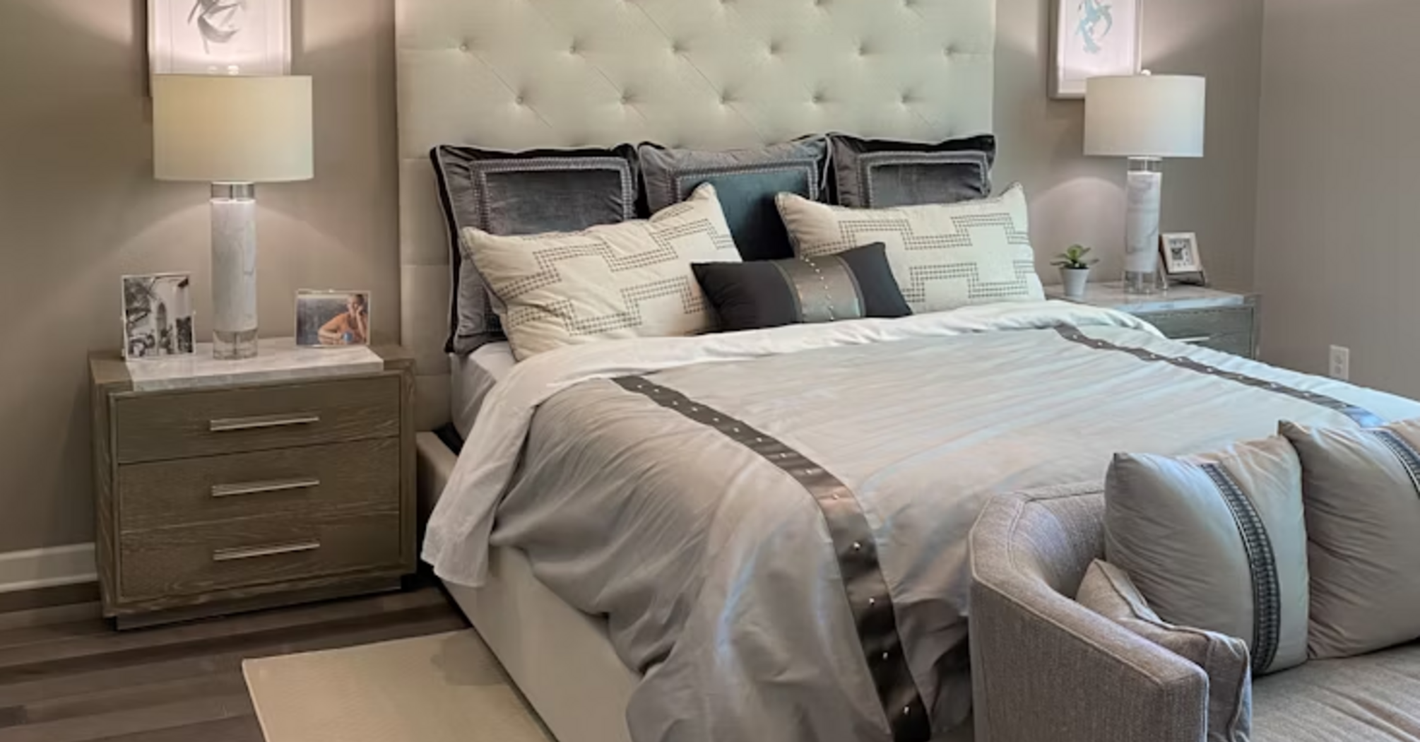 Modern hotel bedroom with neutral tones and tufted headboard