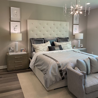 Modern hotel bedroom with neutral tones and tufted headboard