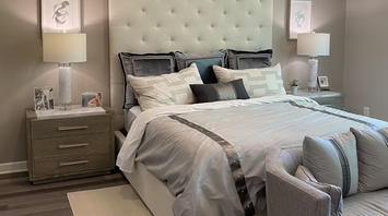 Modern hotel bedroom with neutral tones and tufted headboard