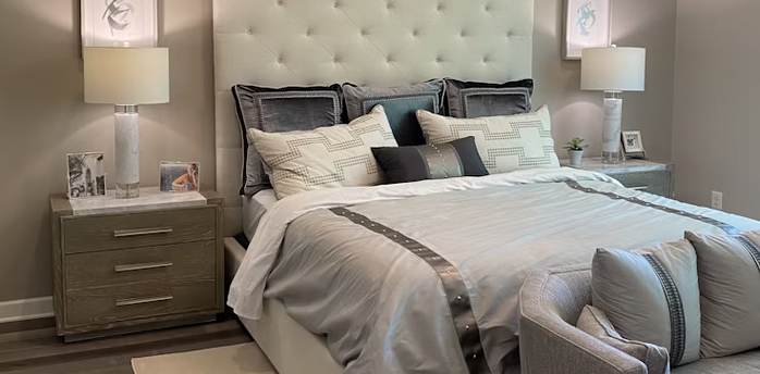 Modern hotel bedroom with neutral tones and tufted headboard