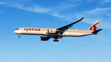 Qatar Airways aircraft in flight against blue sky
