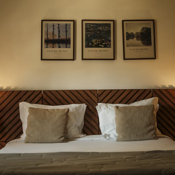 Cozy hotel room with wooden headboard and framed artwork above the bed