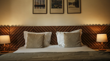 Cozy hotel room with wooden headboard and framed artwork above the bed
