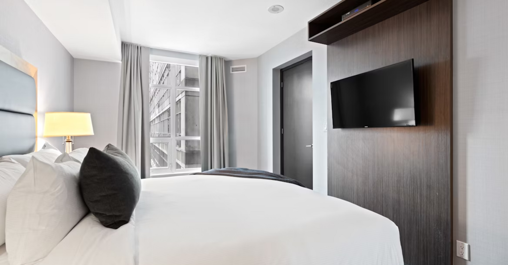 Modern hotel room interior with bed, TV, and window view in Riyadh