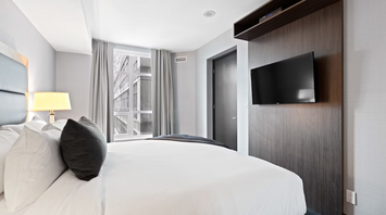 Modern hotel room interior with bed, TV, and window view in Riyadh