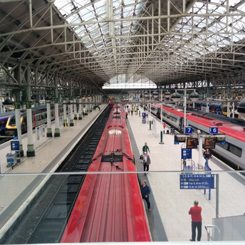 Manchester Piccadilly railway station with multiple platforms and trains during daytime