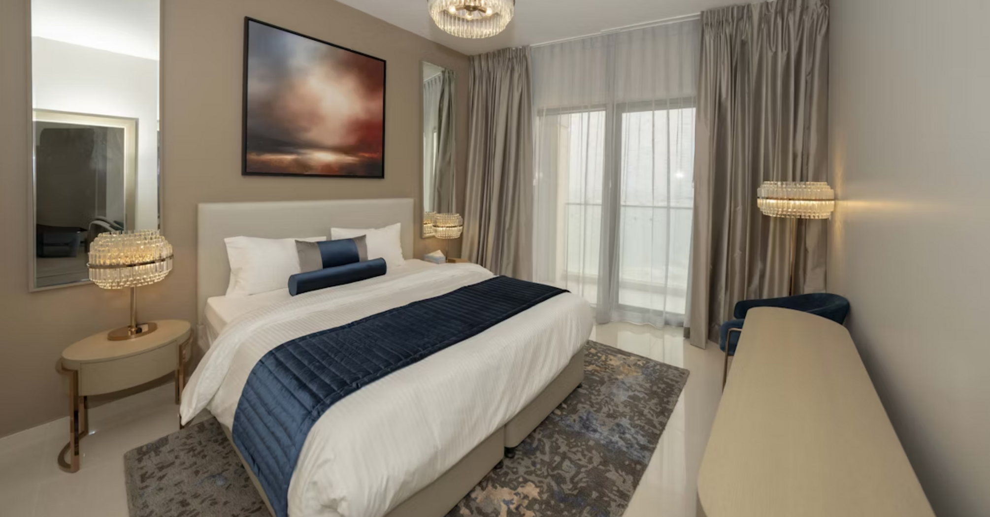 Modern hotel room with neutral tones, large bed, and floor-to-ceiling curtains
