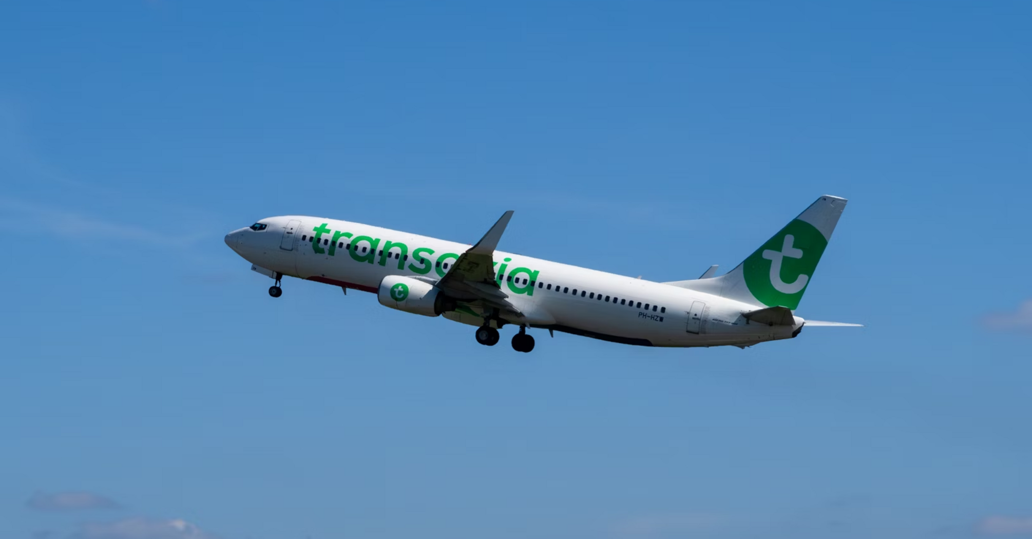 Transavia aircraft taking off under clear blue sky