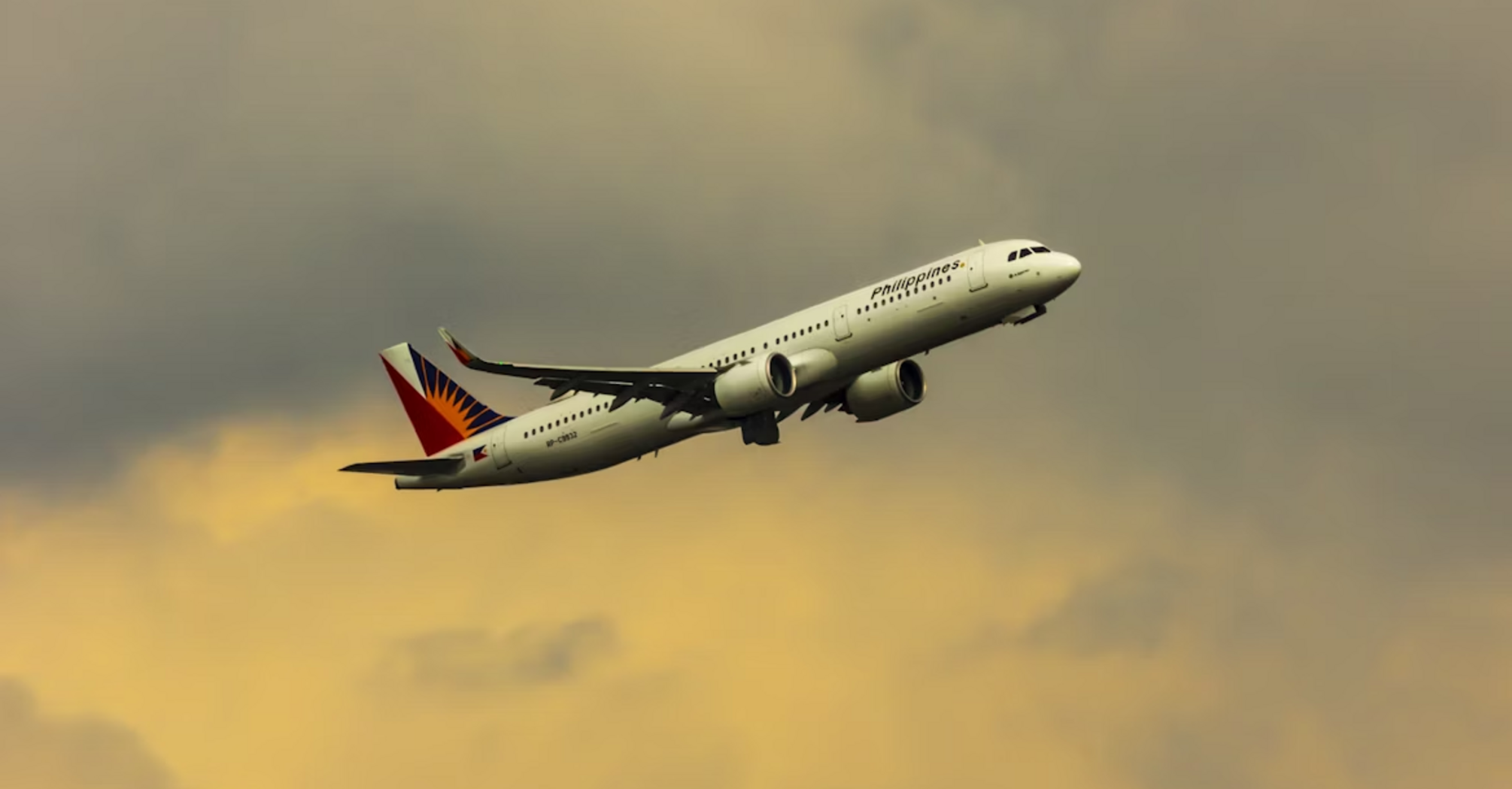 Philippine Airlines aircraft taking off in cloudy sky