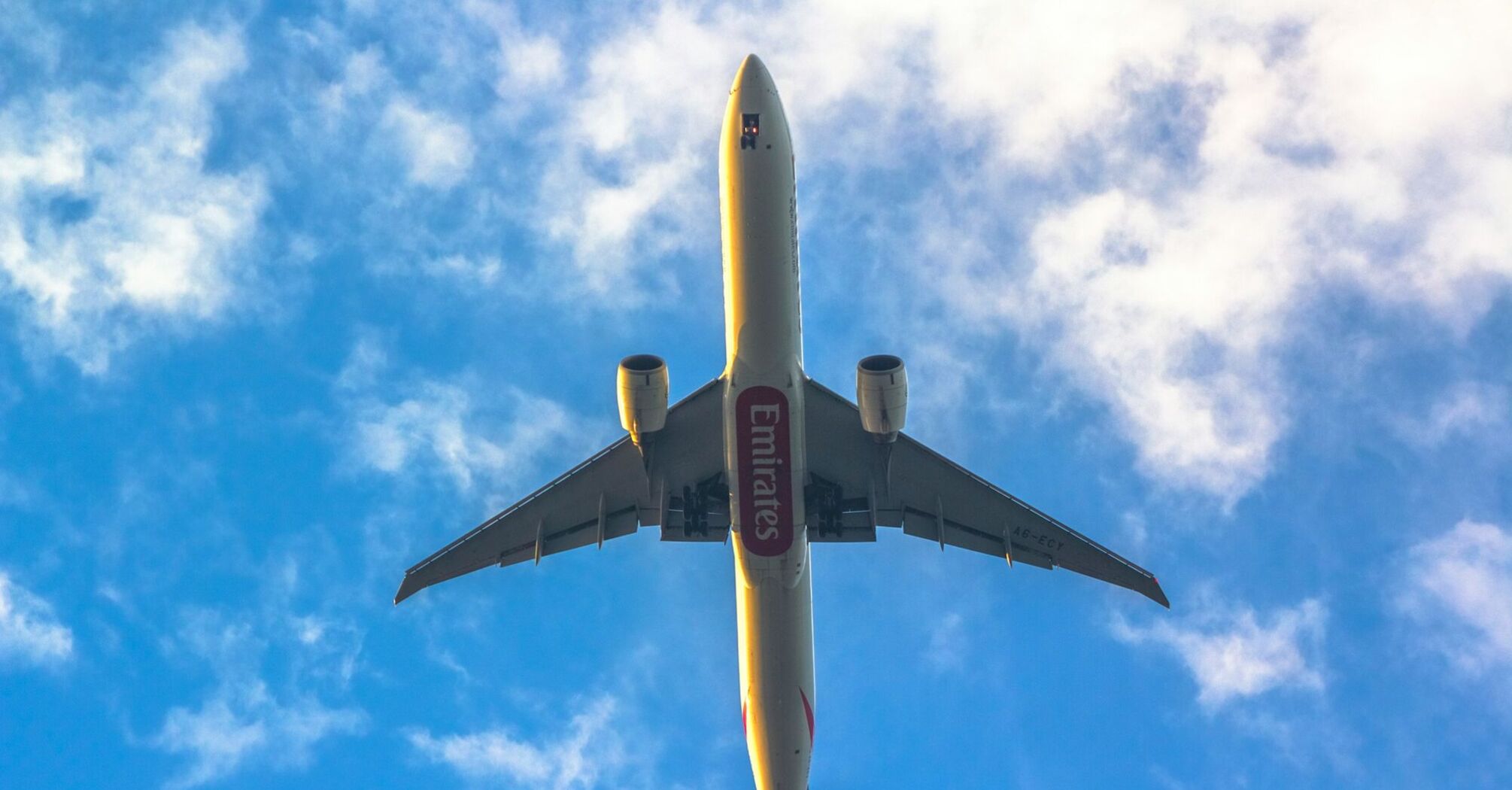 Emirates airplane flying against a blue sky