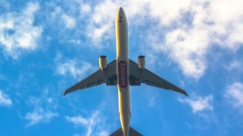 Emirates airplane flying against a blue sky