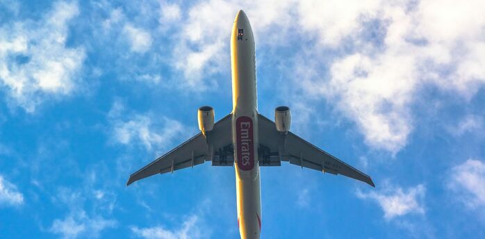 Emirates airplane flying against a blue sky