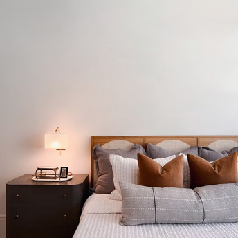 Cozy modern hotel room interior with pillows and bedside lamp