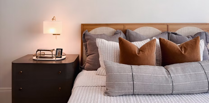 Cozy modern hotel room interior with pillows and bedside lamp