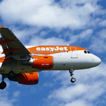 easyJet aircraft in flight against a blue sky with clouds