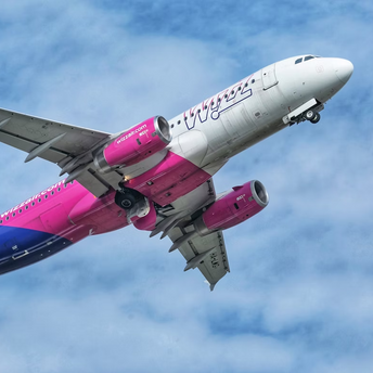 Wizz Air aircraft taking off against a cloudy sky
