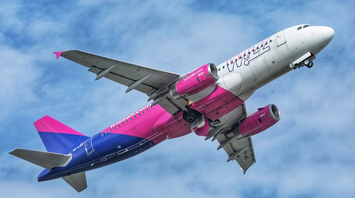 Wizz Air aircraft taking off against a cloudy sky