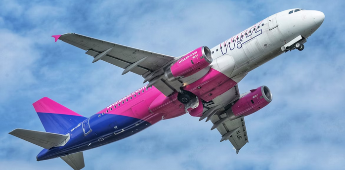 Wizz Air aircraft taking off against a cloudy sky